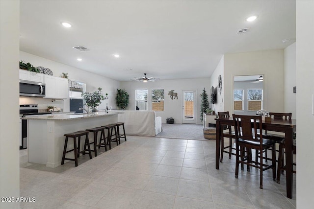 dining room featuring ceiling fan and light carpet