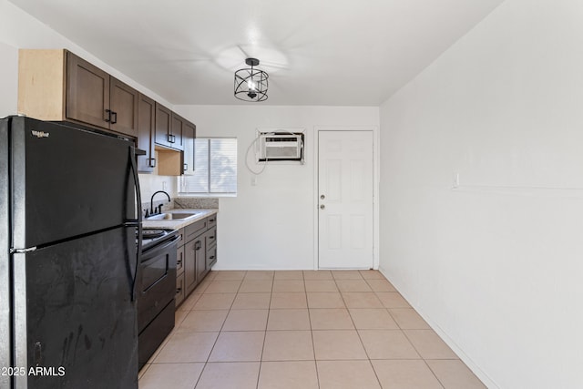 kitchen featuring dark brown cabinetry, sink, a wall mounted air conditioner, light tile patterned floors, and black appliances