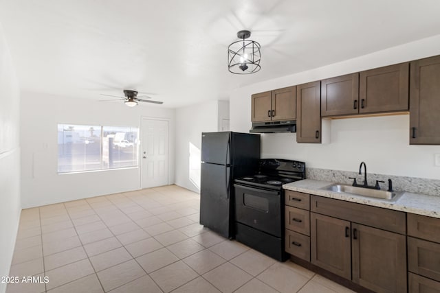 kitchen featuring sink, light tile patterned floors, dark brown cabinetry, black appliances, and decorative light fixtures