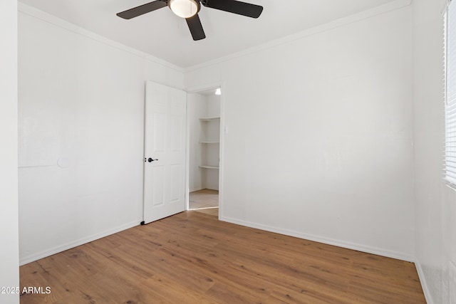 unfurnished room with crown molding, wood-type flooring, and ceiling fan