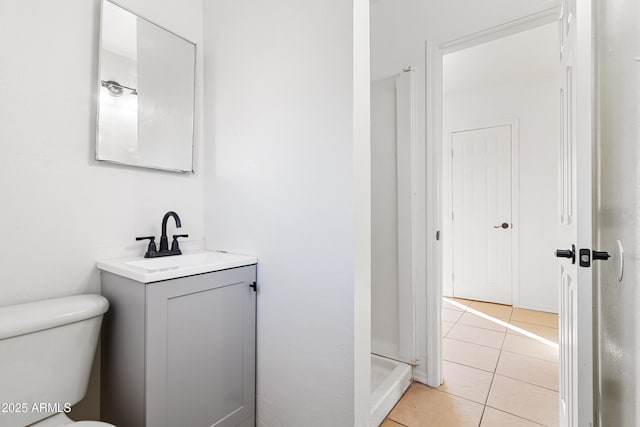 bathroom featuring vanity, tile patterned floors, toilet, and walk in shower