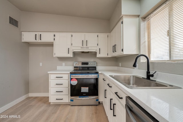 kitchen featuring lofted ceiling, sink, light hardwood / wood-style flooring, appliances with stainless steel finishes, and white cabinetry