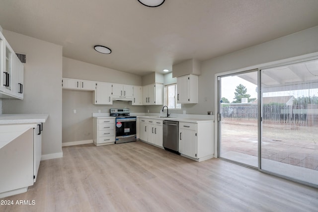 kitchen with white cabinetry, sink, stainless steel appliances, lofted ceiling, and light wood-type flooring