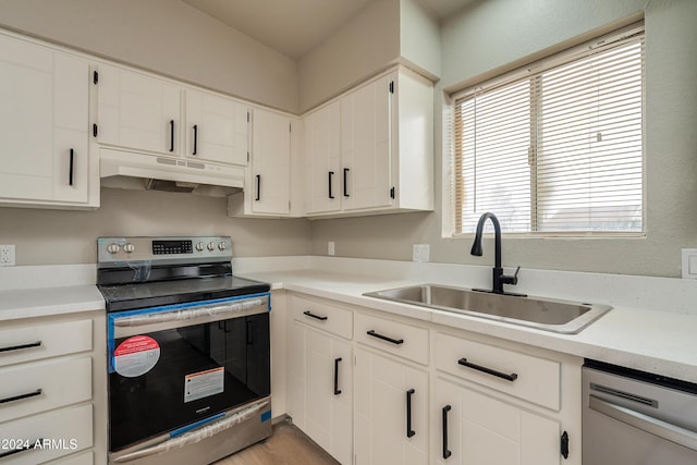 kitchen with white cabinets, appliances with stainless steel finishes, light hardwood / wood-style floors, and sink