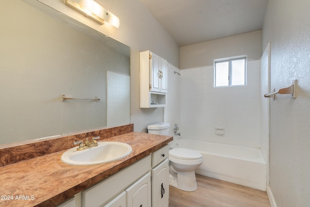 full bathroom with hardwood / wood-style floors, vanity, toilet, and tiled shower / bath