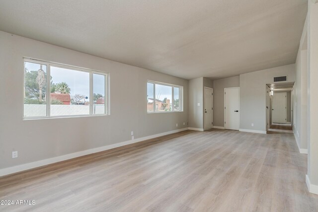 unfurnished bedroom featuring light hardwood / wood-style floors and multiple windows