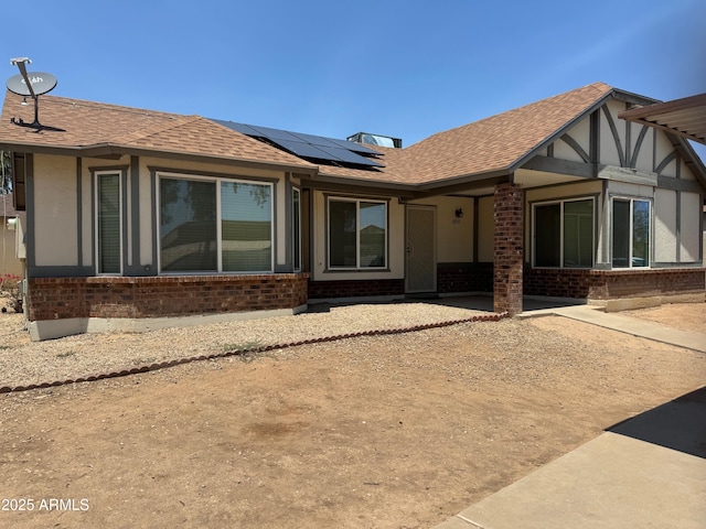 8520 W Palm Ln Unit 1054, Phoenix, AZ 85037 - view of front of house with brick siding, solar panels, and roof with shingles