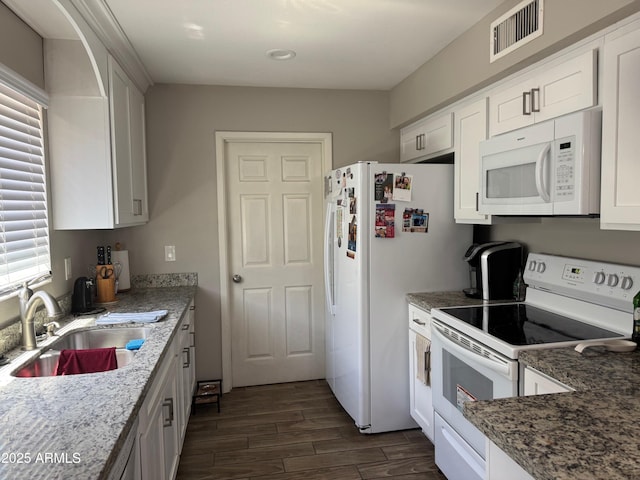 8520 W Palm Ln Unit 1054, Phoenix, AZ 85037 - kitchen with white appliances, dark wood-type flooring, white cabinets, light stone countertops, and recessed lighting