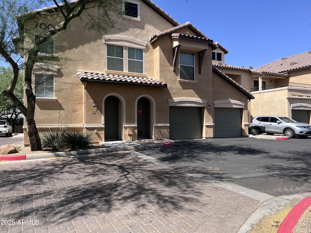 14575 W Mountain View Blvd Unit 711, Surprise, AZ 85374 - view of front of house with stucco siding, a garage, a tile roof, and asphalt driveway