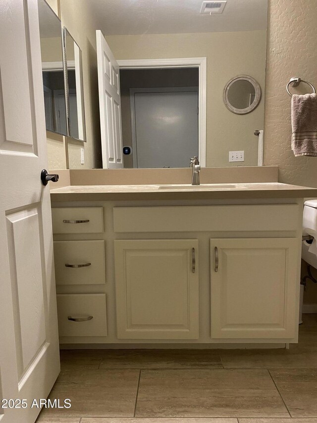 14575 W Mountain View Blvd Unit 711, Surprise, AZ 85374 - bathroom featuring vanity, a textured wall, and wood finished floors