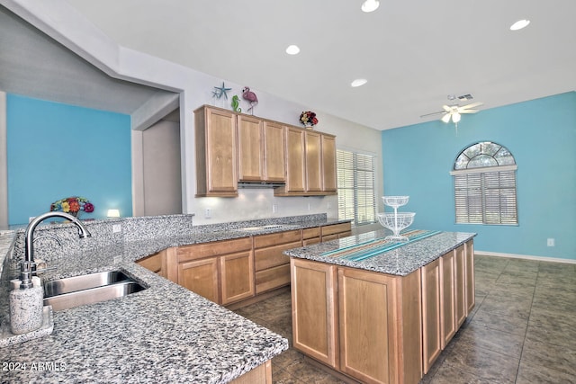 kitchen with ceiling fan, a center island, sink, and stainless steel gas cooktop