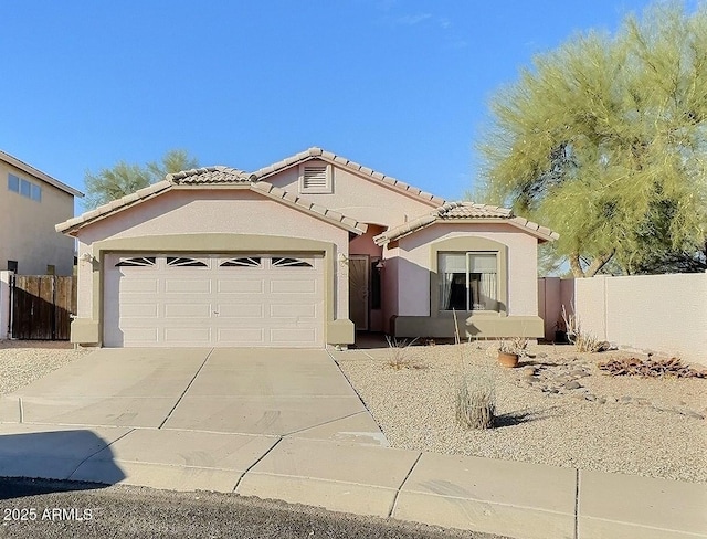 mediterranean / spanish-style home with driveway, an attached garage, fence, and stucco siding