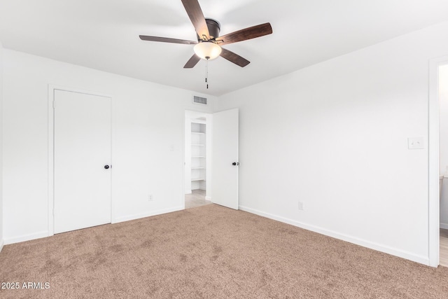 unfurnished bedroom with baseboards, a ceiling fan, visible vents, and light colored carpet