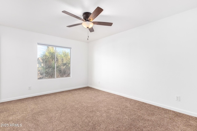 carpeted empty room featuring a ceiling fan and baseboards