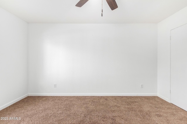 carpeted spare room with ceiling fan and baseboards