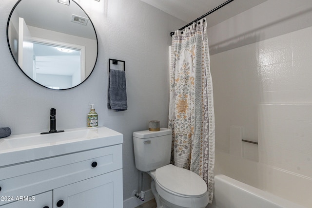 full bathroom with vanity, shower / bath combo with shower curtain, and toilet