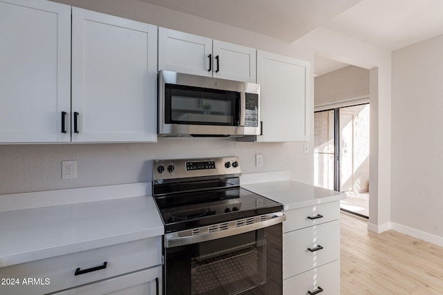 kitchen featuring appliances with stainless steel finishes, white cabinetry, and light wood-type flooring