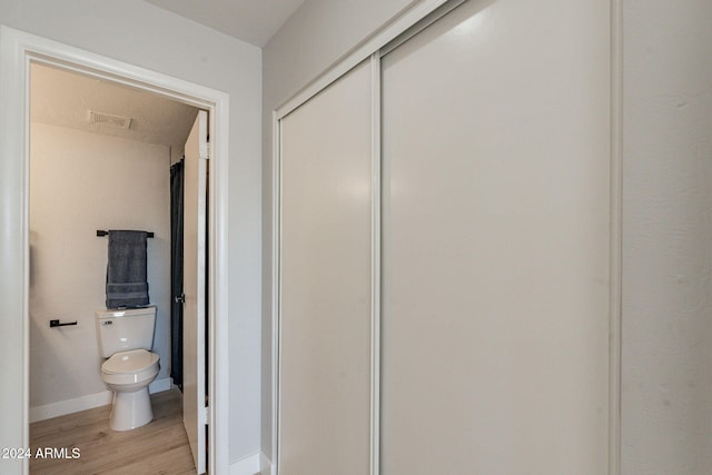 bathroom featuring toilet and wood-type flooring