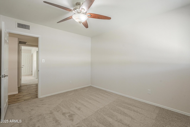 carpeted empty room featuring visible vents and baseboards