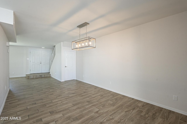 spare room featuring baseboards and wood finished floors