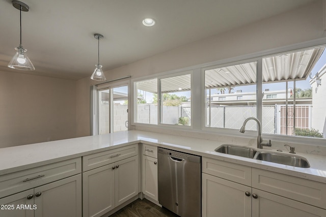 kitchen featuring light stone counters, a healthy amount of sunlight, dishwasher, and a sink