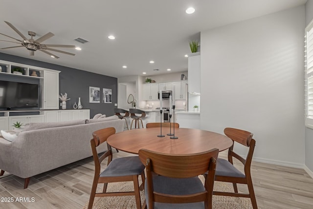 dining area featuring ceiling fan and light wood-type flooring