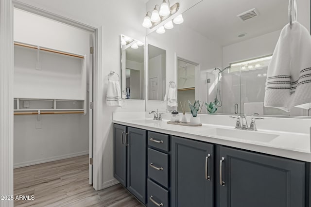 bathroom featuring wood-type flooring, vanity, and a shower with shower door