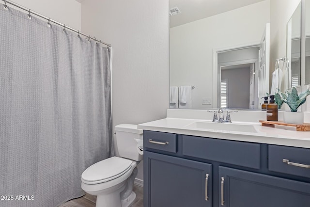 bathroom featuring vanity, wood-type flooring, and toilet