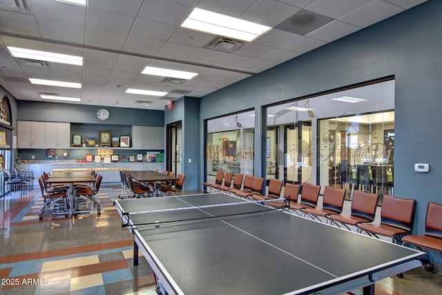 rec room with a paneled ceiling