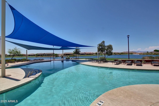 view of swimming pool with a patio and a water view