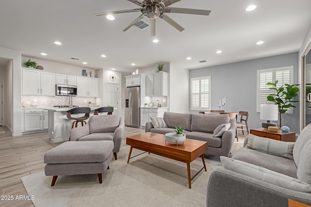 living room featuring ceiling fan and light hardwood / wood-style flooring