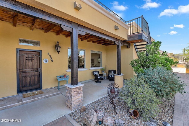 doorway to property featuring a balcony and stucco siding