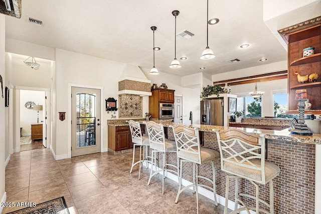 kitchen with visible vents, open shelves, a breakfast bar area, and stainless steel appliances