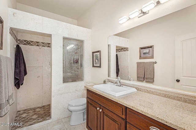 full bathroom with vanity, tile patterned floors, a tile shower, and toilet