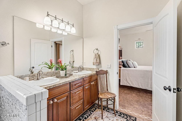 bathroom featuring double vanity, a sink, and ensuite bath