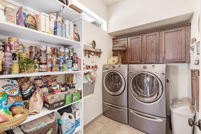 clothes washing area featuring cabinet space and washing machine and clothes dryer