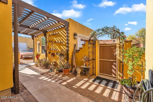 view of patio with a pergola and a gate
