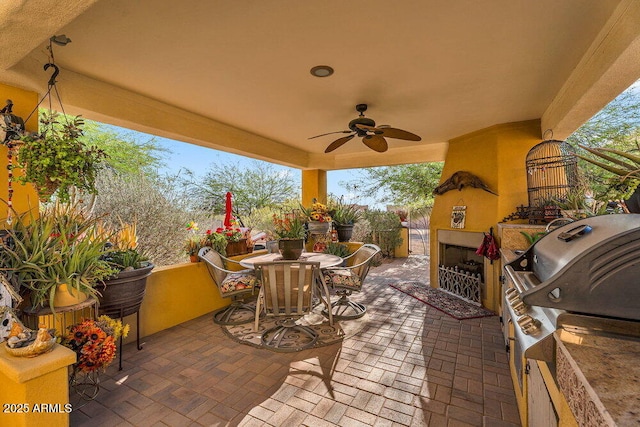 view of patio with a ceiling fan, exterior fireplace, and outdoor dining space