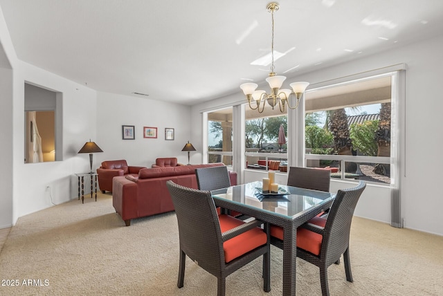 carpeted dining area featuring an inviting chandelier