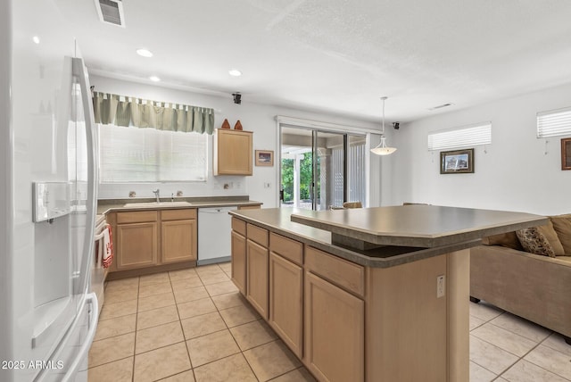 kitchen featuring pendant lighting, sink, white appliances, a kitchen island, and light brown cabinetry