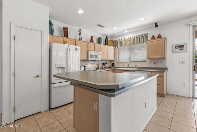 kitchen with white appliances, a center island, light brown cabinets, and light tile patterned floors