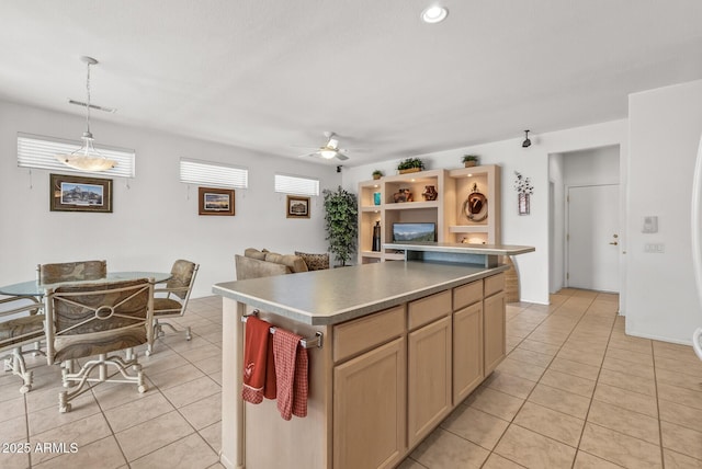 kitchen with ceiling fan, a center island, hanging light fixtures, and light tile patterned floors