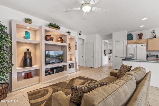 living room with built in features, ceiling fan, and light tile patterned flooring