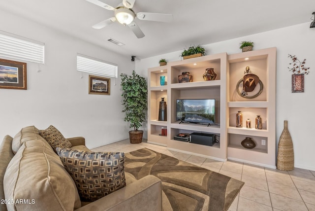 living room with light tile patterned flooring, ceiling fan, and built in shelves