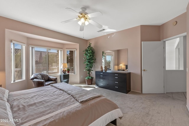 bedroom with multiple windows, light colored carpet, and ceiling fan