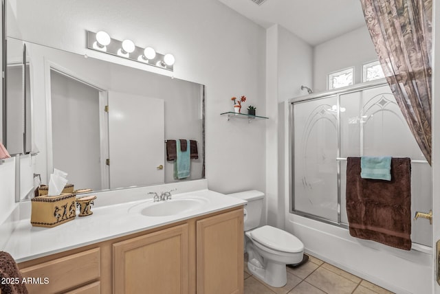 full bathroom featuring tile patterned floors, toilet, combined bath / shower with glass door, and vanity