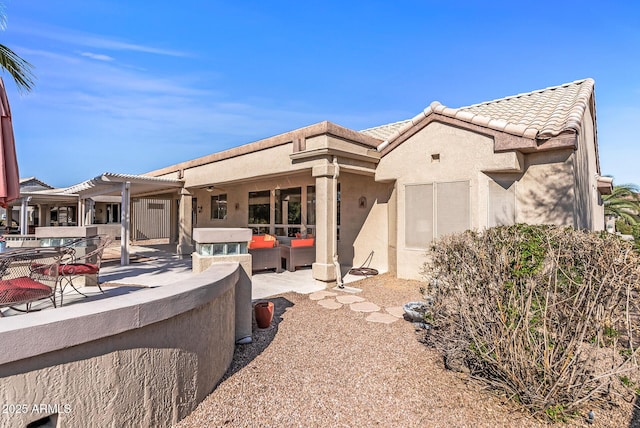 back of property with a pergola, a patio area, and outdoor lounge area