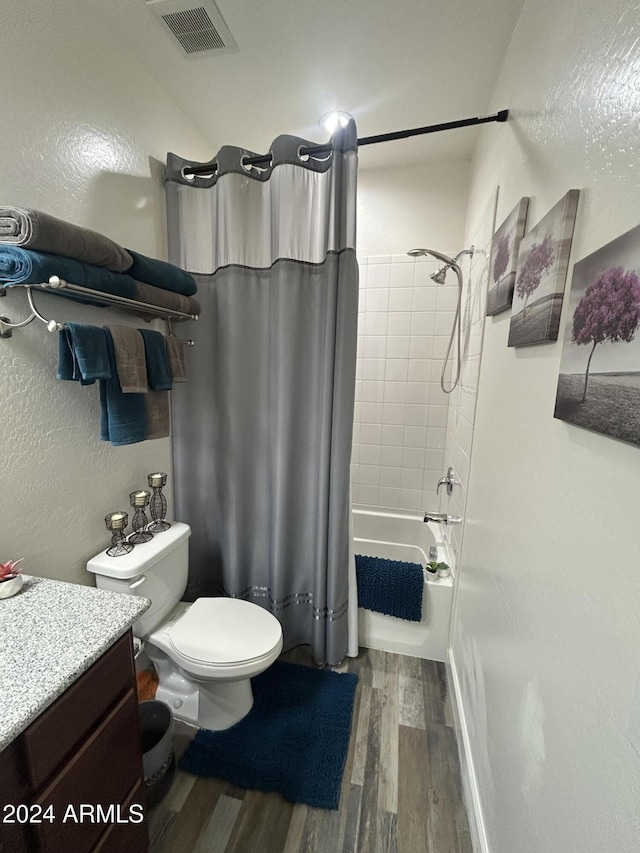 full bathroom featuring hardwood / wood-style floors, shower / bath combo, toilet, and vanity