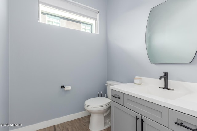 bathroom with hardwood / wood-style floors, toilet, and vanity