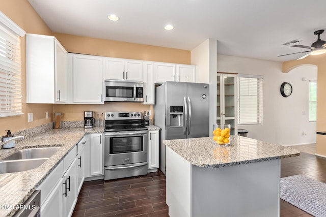 2031 N 77th Ln, Phoenix, AZ 85035 - kitchen with stainless steel appliances, a sink, wood tiled floors, a kitchen island, and light stone counters